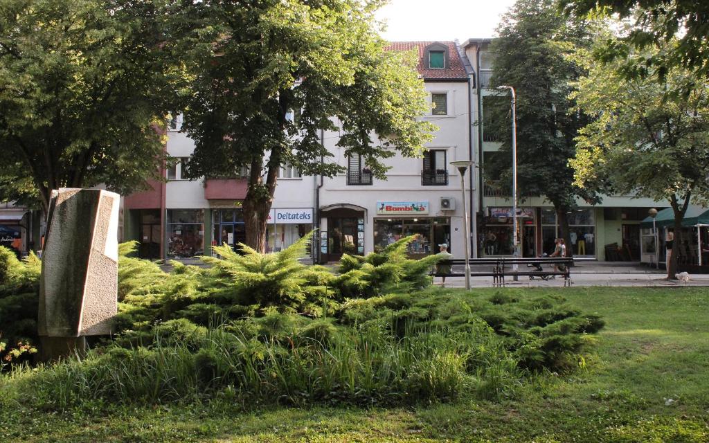 un parco con cespugli di fronte a un edificio di Hacijenda a Bajina Bašta