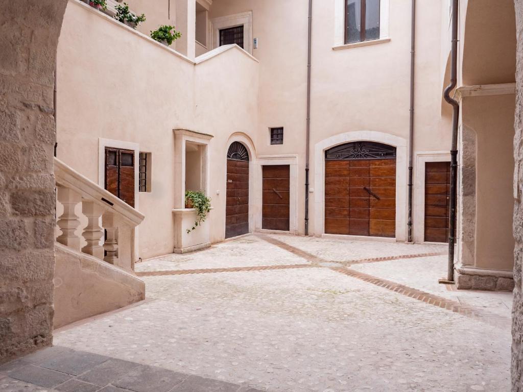 an alley with two garage doors in a building at Palazzo dei Pavoni, Relais di Charme in LʼAquila