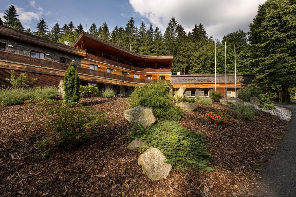 un edificio con un jardín delante de él en Horský hotel Lorkova vila en Čeladná