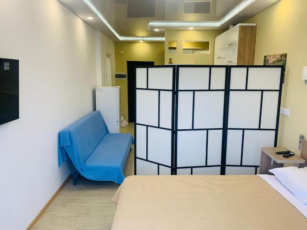 巴统Downtown Batumi apartment的配有床和蓝椅的房间
