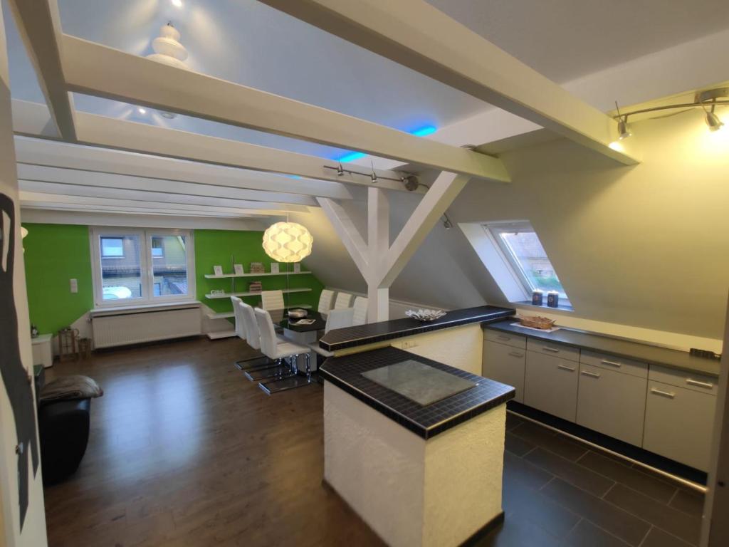 une cuisine et une salle à manger aux murs verts dans l'établissement Ferienwohnung Neugebauer, à Bockhorn