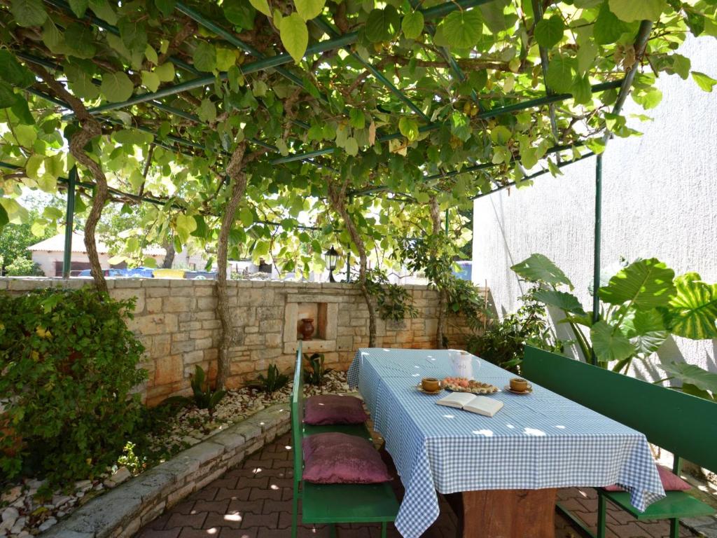 a blue table and chairs under a pergola at Holiday Home Milka 1 - ROJ315 by Interhome in Svetvinčenat