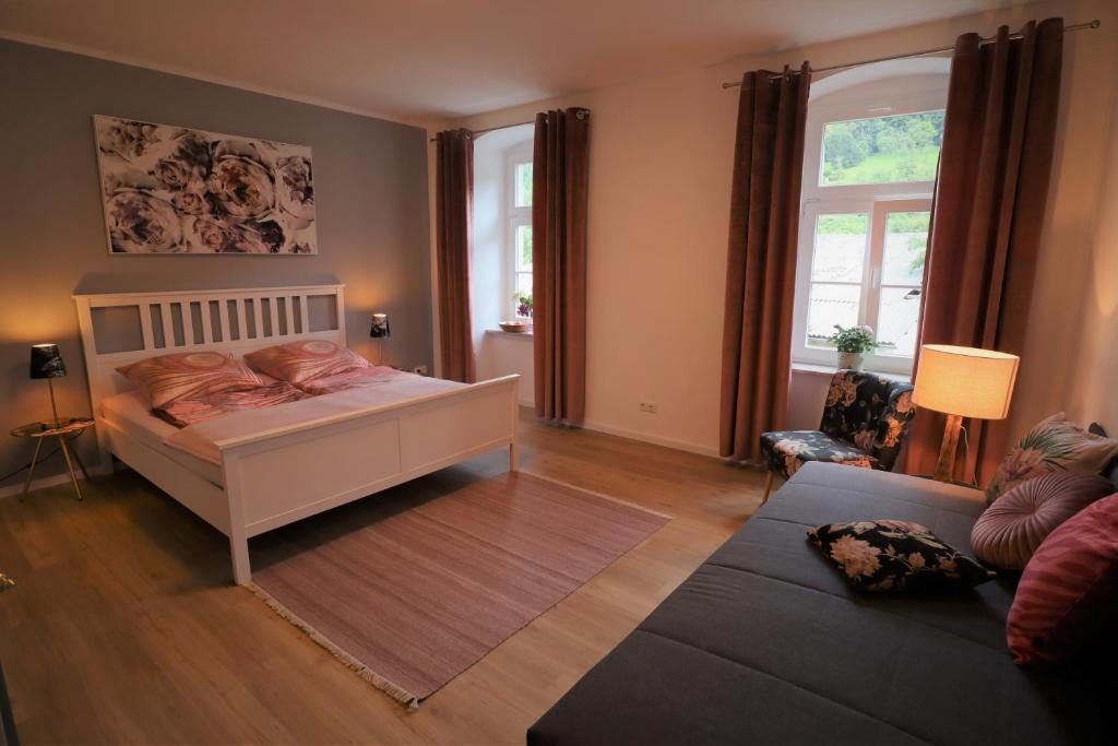 a bedroom with a bed and a couch at Ferienwohnung zum Bielatal in Königstein an der Elbe