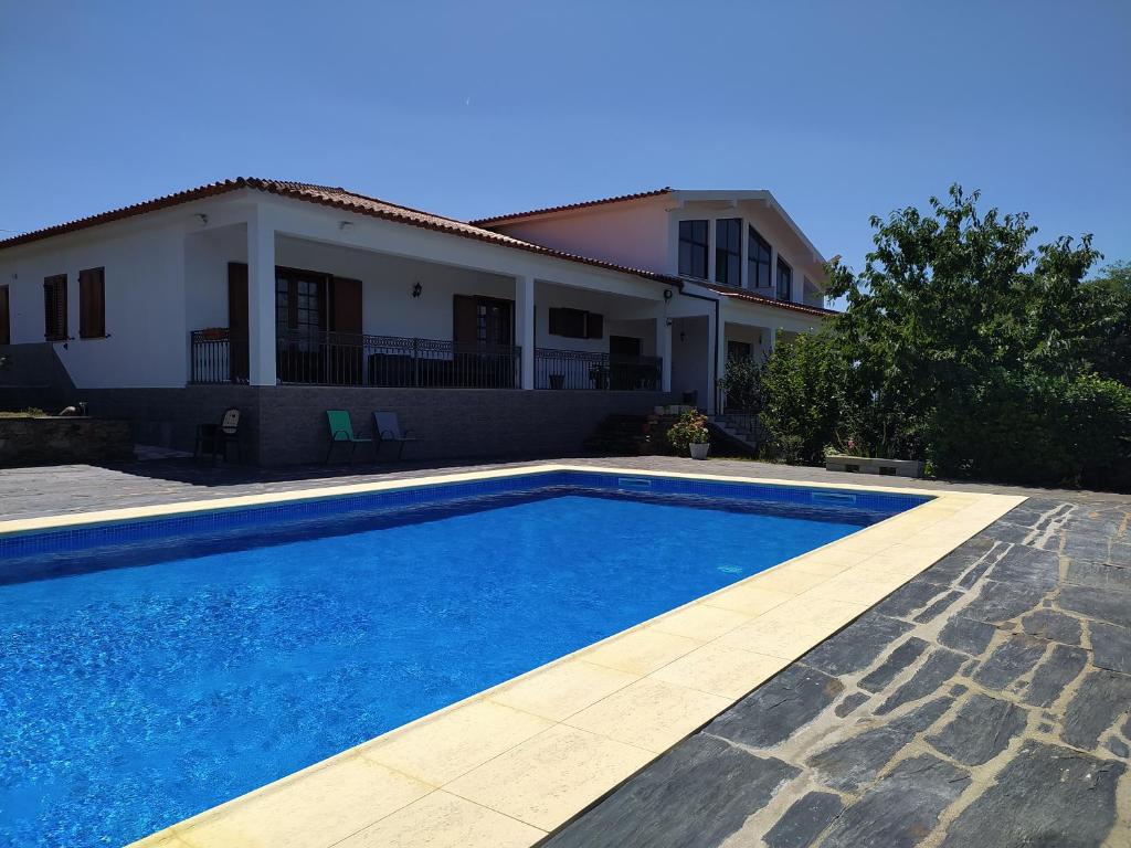 a swimming pool in front of a house at Vivenda das Eiras in Vale de Porco