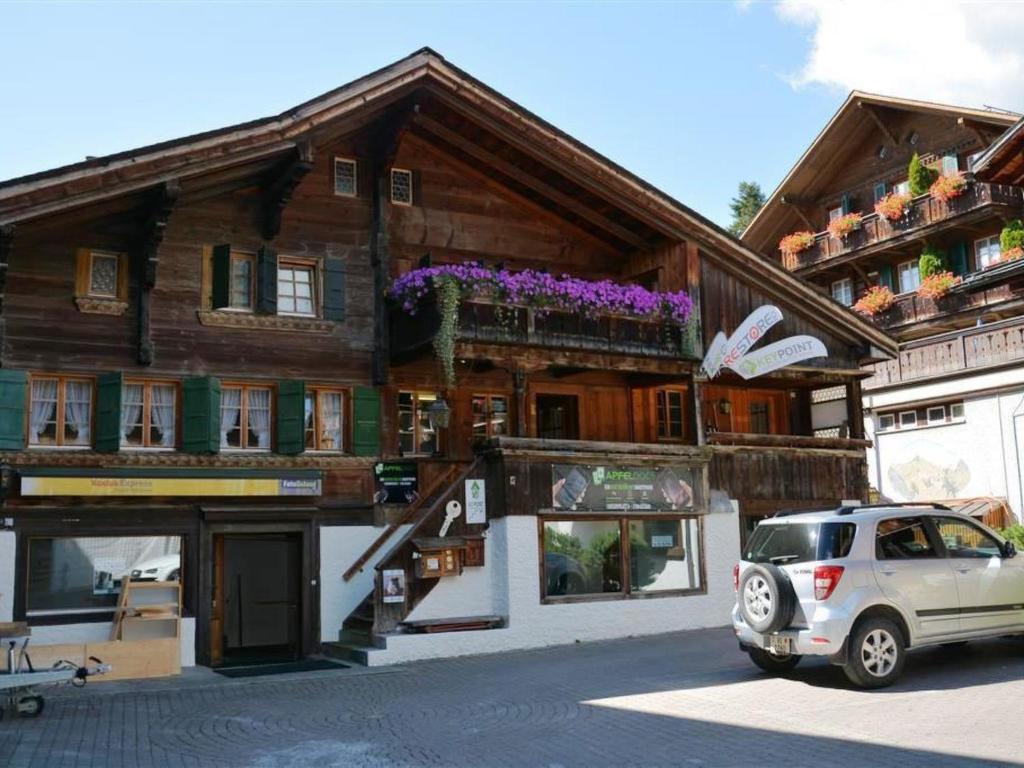 a car parked in front of a wooden building at Apartment Le Vieux Chalet by Interhome in Gstaad
