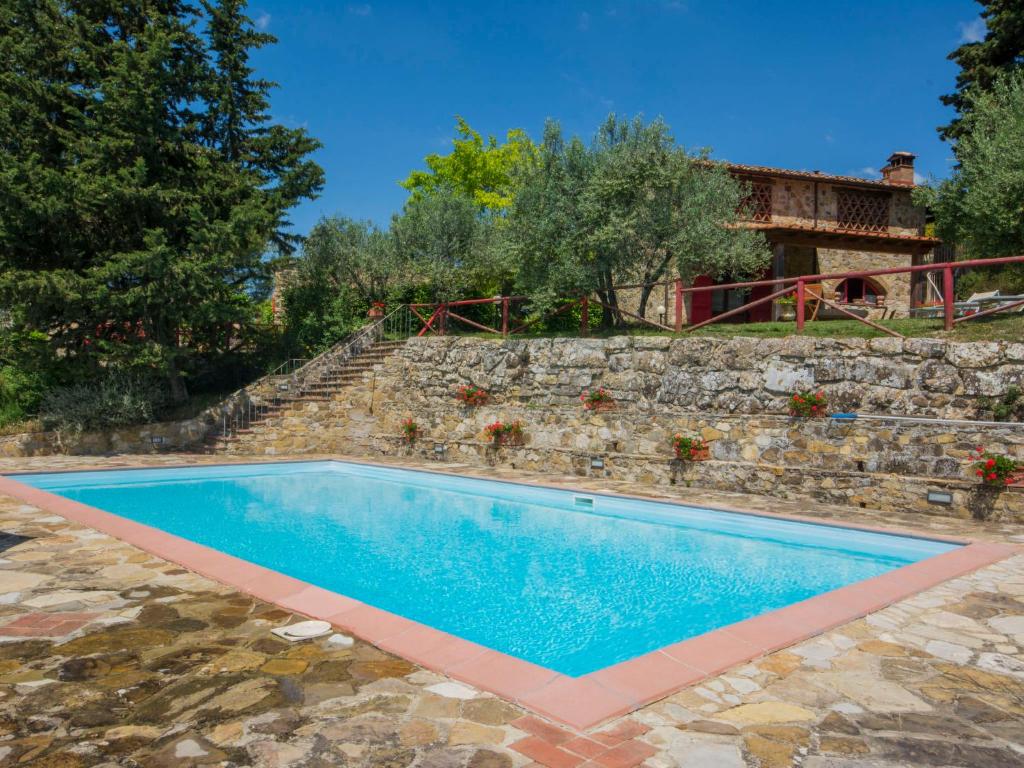 una piscina frente a una pared de piedra en Holiday Home Badia a Passignano by Interhome, en Badia A Passignano