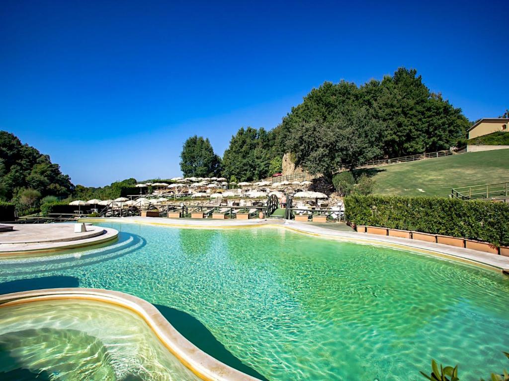 a swimming pool with turquoise water and umbrellas at Apartment Thermae Apartment 25 by Interhome in Sorano