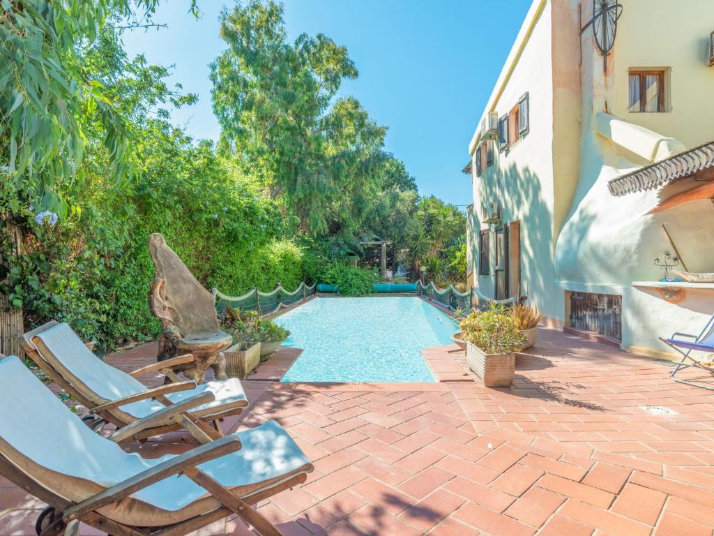 Un patio con sillas y una piscina. en Holiday Home Sergio by Interhome, en Codaruina