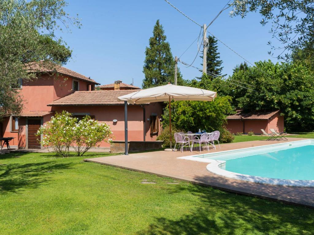 uma casa com piscina e guarda-sol em Villa Casal di Yuri by Interhome em Vetralla