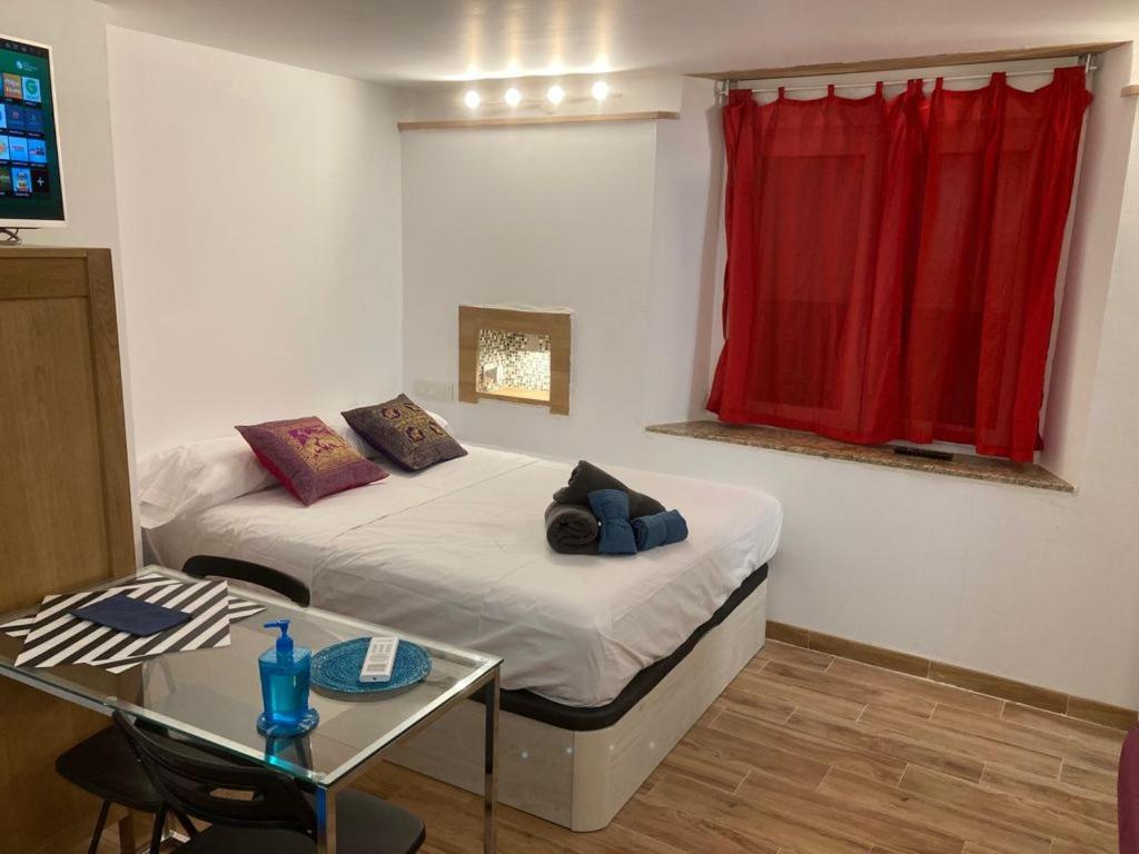 a room with two beds and a red window at Malagueña Salerosa "Apartamento - estudio con terraza" En casa típica de 1 a 4 dormitorios in Málaga