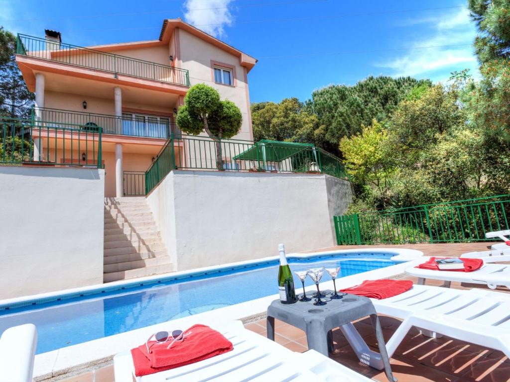 a villa with a swimming pool and a house at Holiday Home Arauco by Interhome in Lloret de Mar