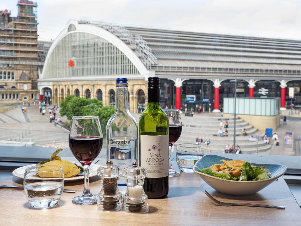 uma mesa com duas garrafas de vinho e uma taça de comida em Holiday Inn Liverpool City Centre, an IHG Hotel em Liverpool