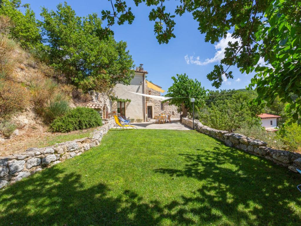 a yard with a stone wall and a house at Holiday Home Rosario by Interhome in Gessopalena