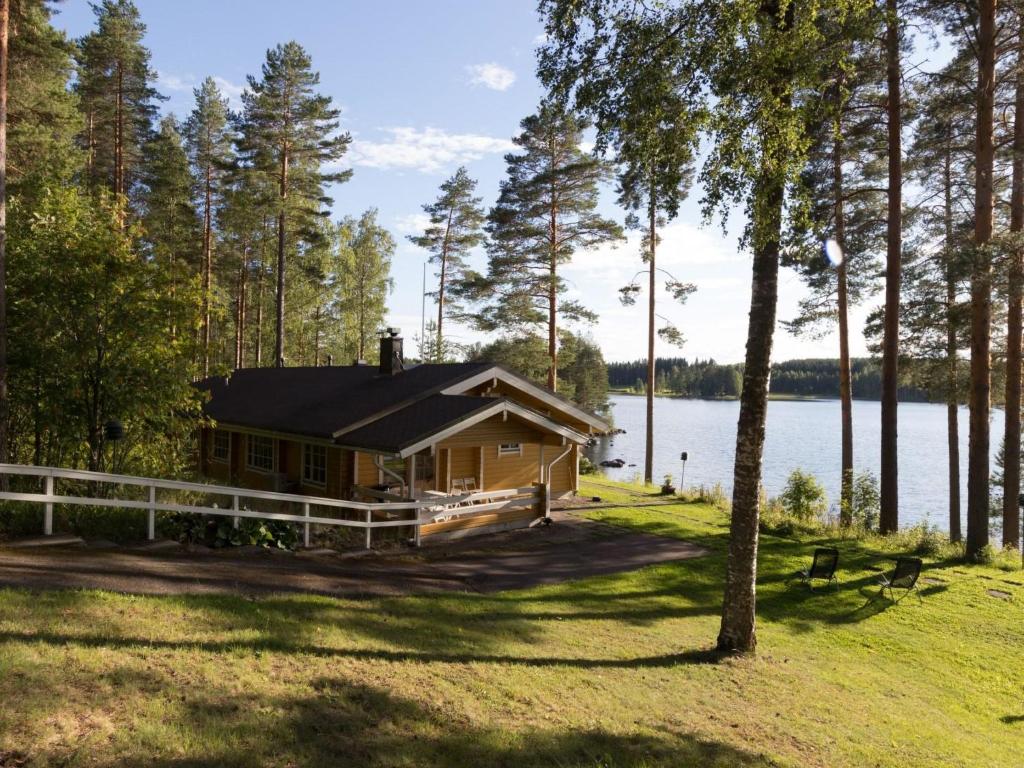 una cabaña de madera a orillas de un lago en Holiday Home Konnusmaja by Interhome, en Leppävirta