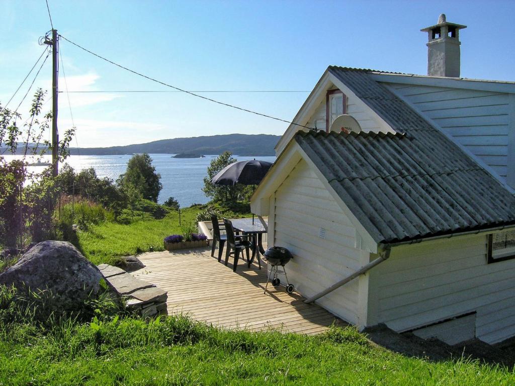FlygansværにあるHoliday Home Soltun - FJH633 by Interhomeの水辺の木製デッキ付きの家