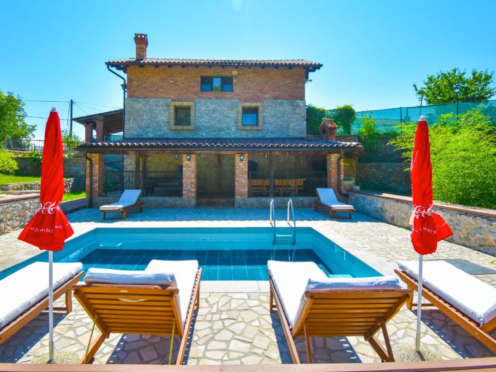 una piscina con due sedie e due ombrelloni di Holiday Home Natura - OPA150 by Interhome a Ičići