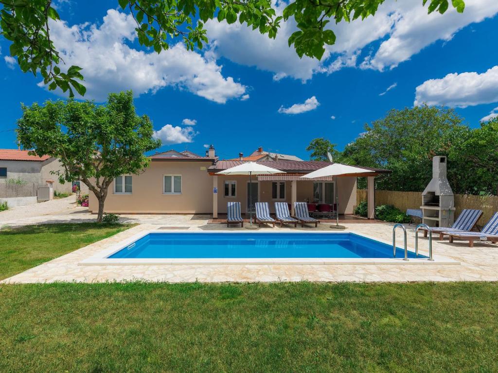 a swimming pool in a yard with chairs and a house at Holiday Home Vrt - ROJ459 by Interhome in Sveti Petar u Šumi