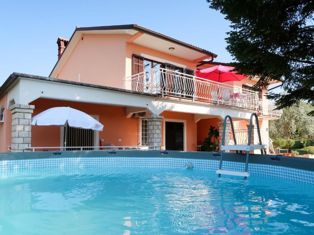 a villa with a swimming pool in front of a house at Apartment Mirjana - LBN312-2 by Interhome in Ružići