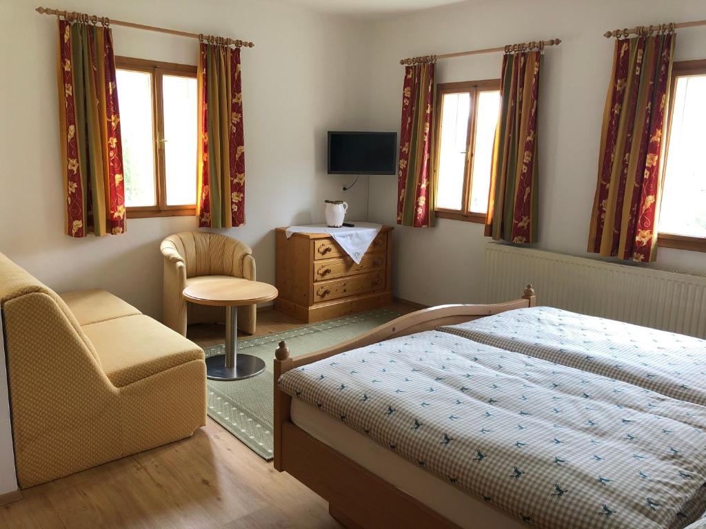 1 dormitorio con 1 cama y 1 silla en Stapflhof en Bad Aussee