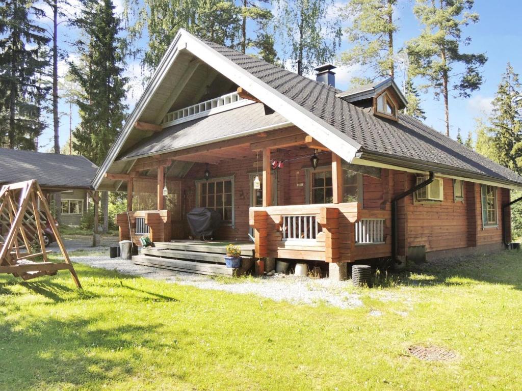 Holiday Home Purnukka by Interhome في Kolinkylä: منزل خشبي كبير مع شرفة وساحة