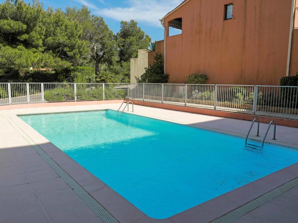 - une piscine d'eau bleue en face d'un bâtiment dans l'établissement Apartment Résidence Les Sangliers by Interhome, à Saint-Raphaël