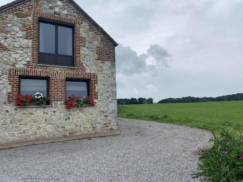 a brick building with two windows with flowers on it at A l'orée du Bois in Landelies