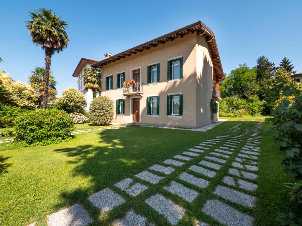 een huis met een palmboom en een gazon bij Holiday Home Casa Con Le Rose by Interhome in San Daniele del Friuli