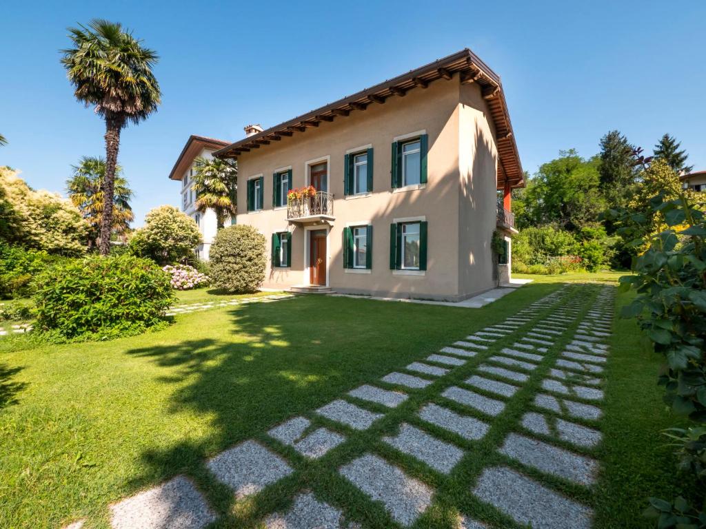 dom z palmą i trawnikiem w obiekcie Holiday Home Casa Con Le Rose by Interhome w mieście San Daniele del Friuli