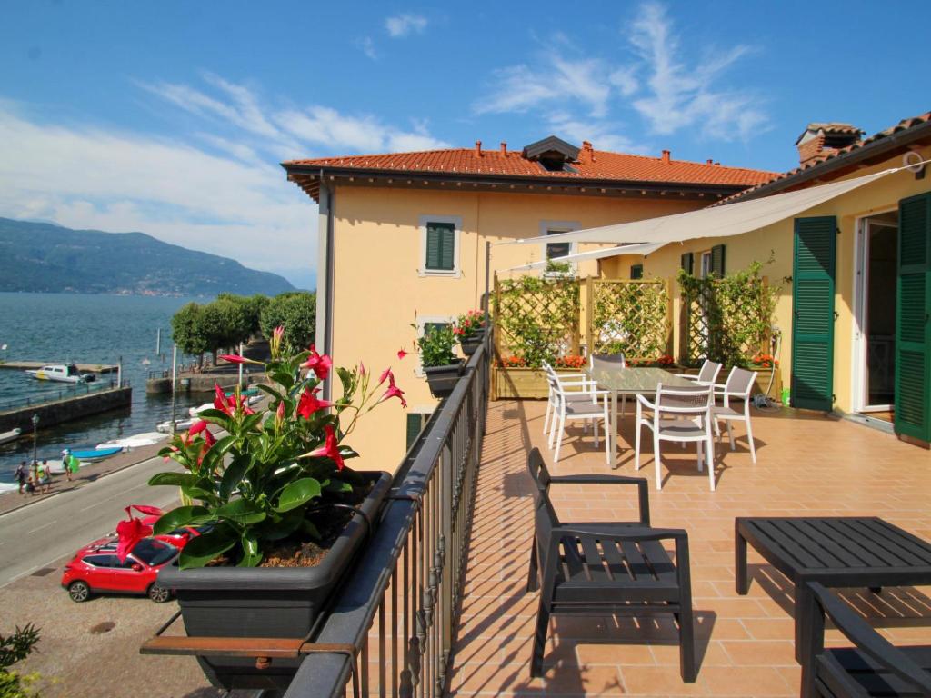 een balkon van een huis met een tafel en stoelen bij Apartment Atmosfere sul lago by Interhome in Porto Valtravaglia