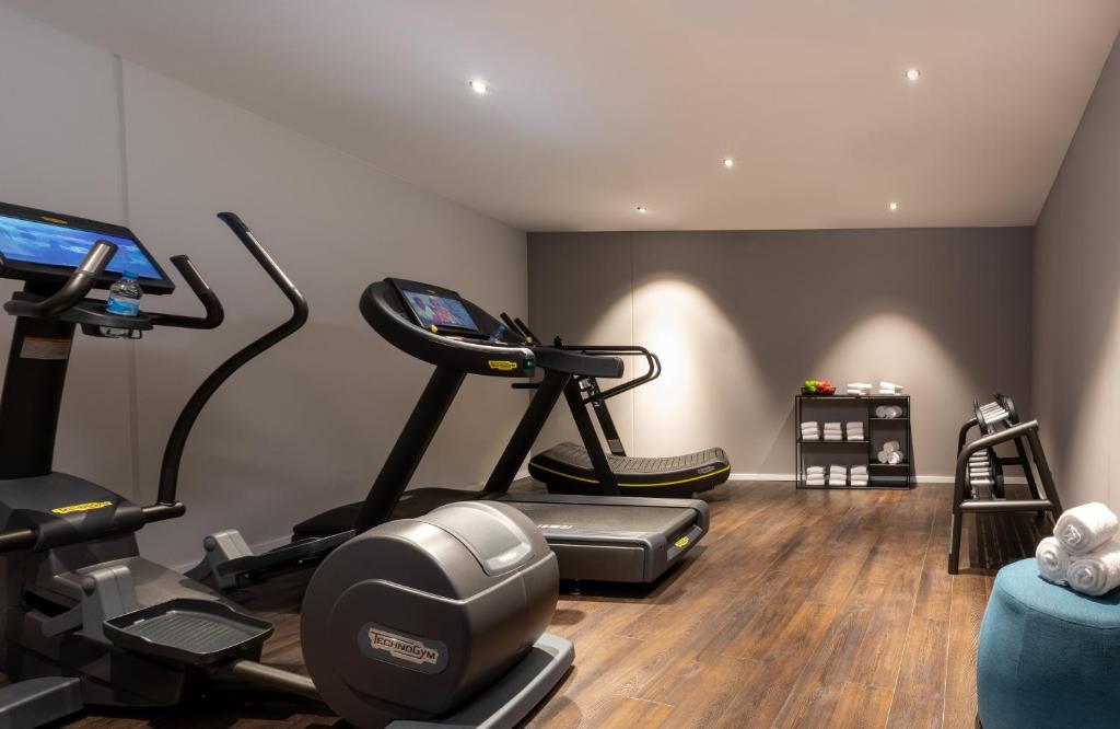 a gym with two exercise bikes and a treadmill at Leonardo Hotel Dortmund in Dortmund