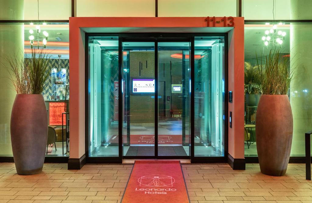 an entrance to a building with two large glass doors at Leonardo Hotel Dortmund in Dortmund