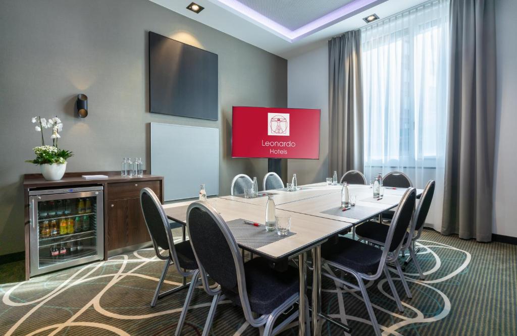 a conference room with a large table and chairs at Leonardo Hotel Dortmund in Dortmund