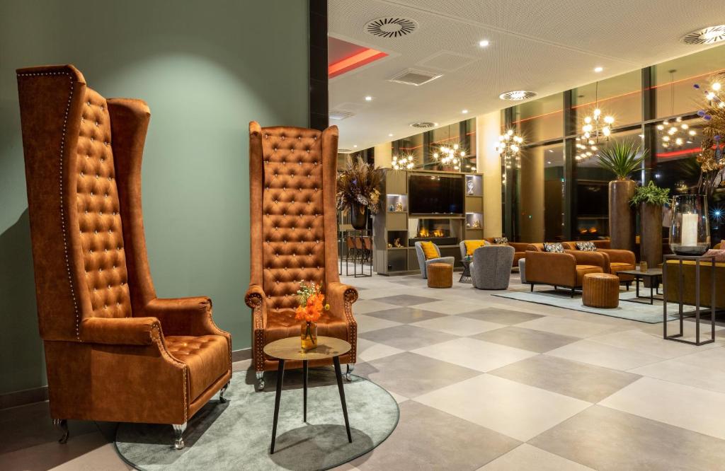 a lobby with two chairs and a barber shop at Leonardo Hotel Dortmund in Dortmund