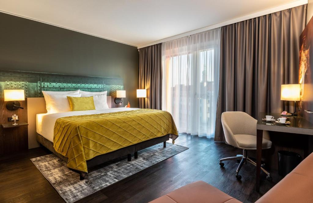 Pokój hotelowy z łóżkiem i biurkiem w obiekcie Leonardo Hotel Dortmund w Dortmundzie
