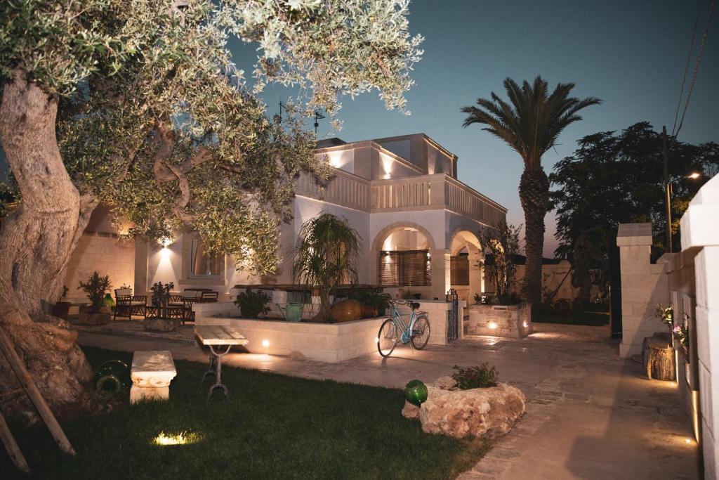una casa blanca con un árbol y luces en el patio en Villa Luis, en Fasano