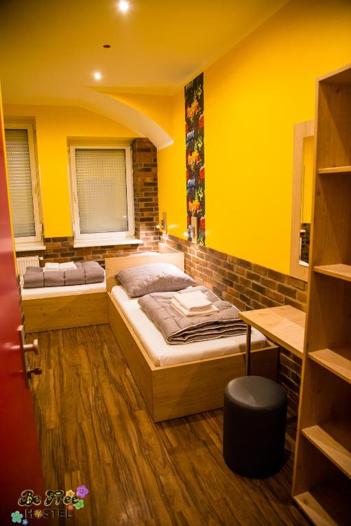 two beds in a room with yellow walls at BeFree Hostel - Self-Service in Vienna