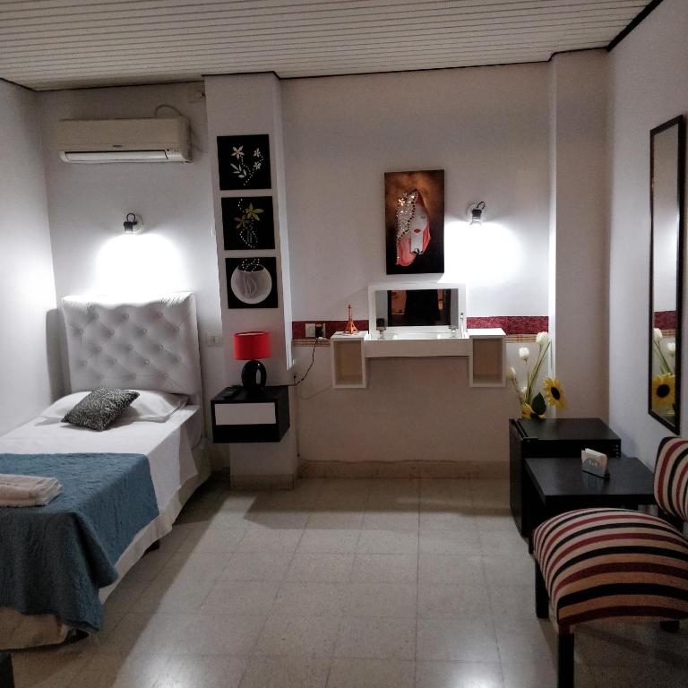 a bedroom with a bed and a desk in it at Rosa Ramona Rooms in San Salvador de Jujuy