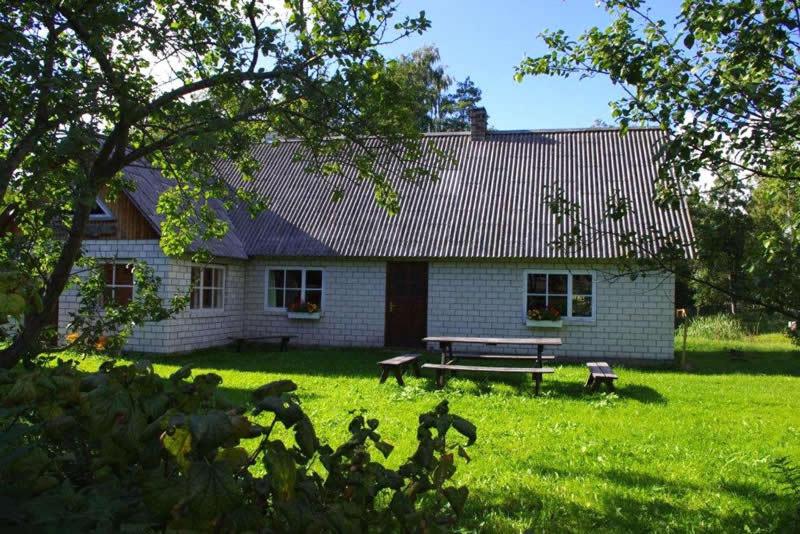 a white house with a picnic table in front of it at Sepa Jõe Holiday Home in Riksu