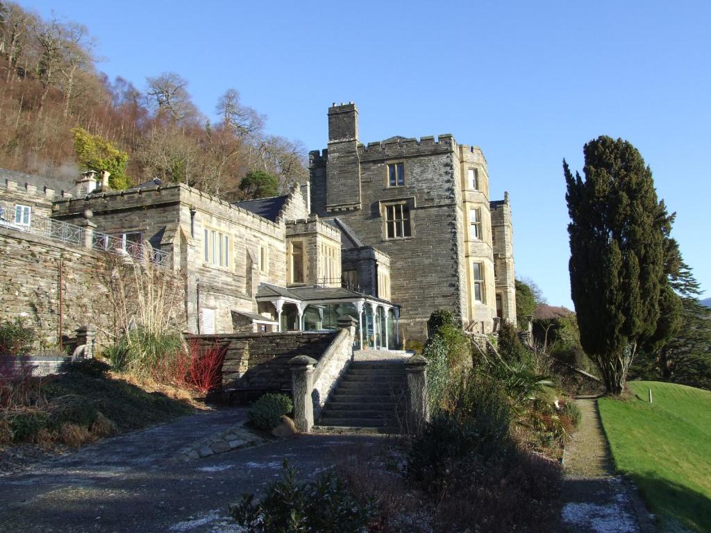 an old stone house with stairs leading up to it at Plas Tan y Bwlch in Maentwrog