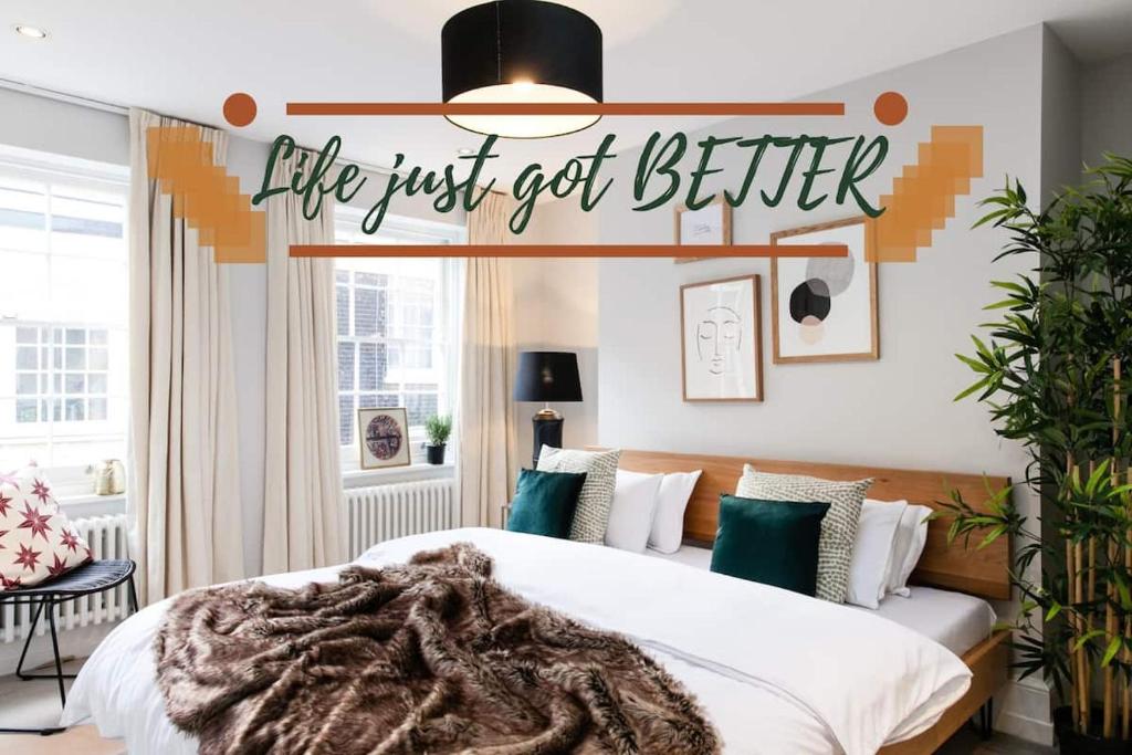 a bedroom with a bed with a sign that reads life just got better at 1st Class Covent Garden Residences for 1st Class Guests in London