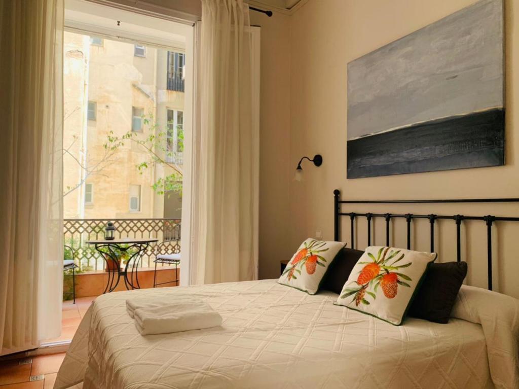 a bedroom with a bed and a large window at Casa Consell Gran Via, Guest House in Barcelona