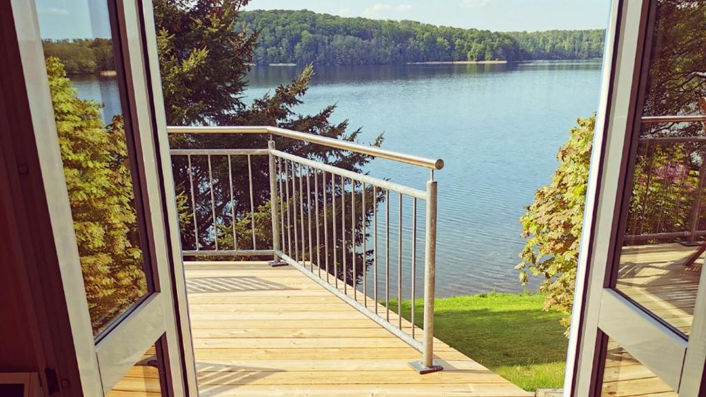 a balcony with a view of a lake at Ferienhaus SeeWaldMeer am Pinnower See bei Schwerin in Pinnow