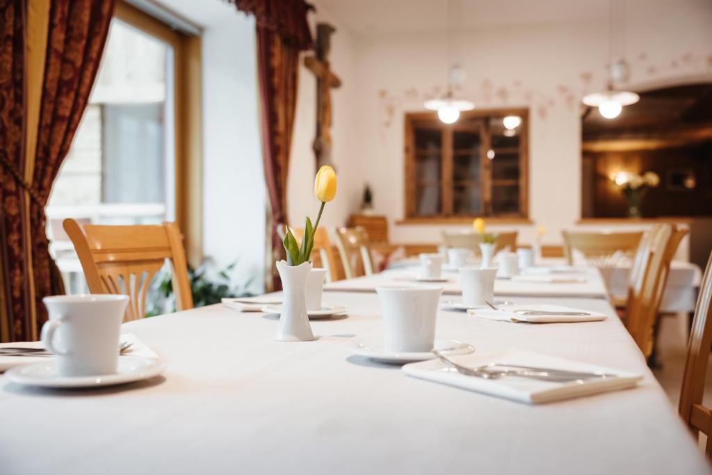 a long table with white dishes and flowers on it at Garni Ciasa Urban in Badia