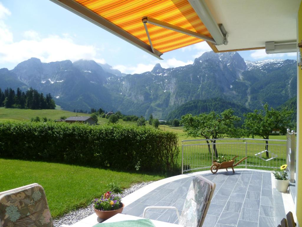 un patio con un banco y montañas al fondo en Apartement Obweghof Abtenau, Salzburger Land en Abtenau