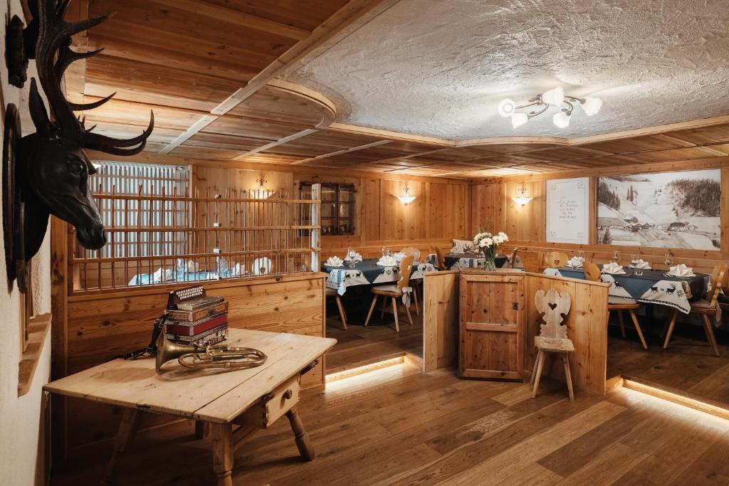 a dining room with a table and some tables and chairs at Garni Ciasa Urban in Badia