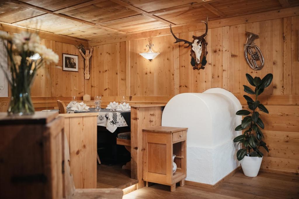 a room with wooden walls and a kitchen with a table at Garni Ciasa Urban in Badia
