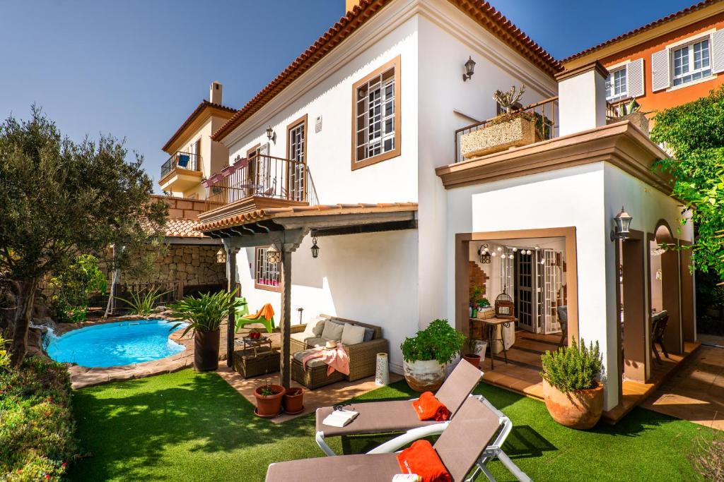 a house with a backyard with a swimming pool at DELUXE VILLA BELLA VITA AIR CON & HEATED POOL, Tenerife South in Chayofa