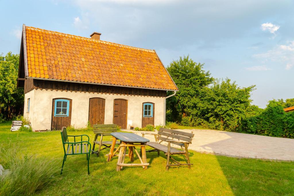 a picnic table and chairs in front of a house at Apartament Na Skraju Miasta in Mikołajki