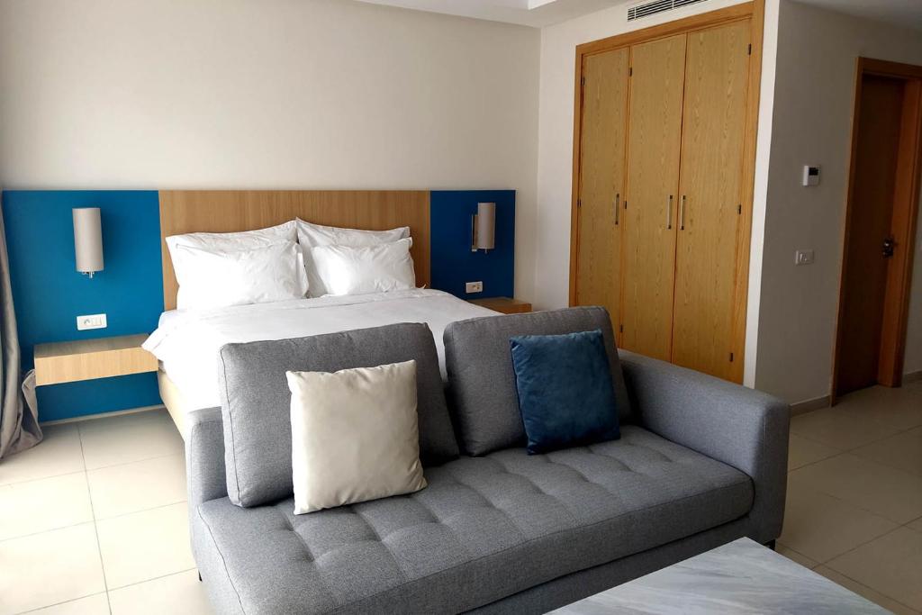 a bedroom with a bed and a couch in it at Zephyr Agadir in Agadir
