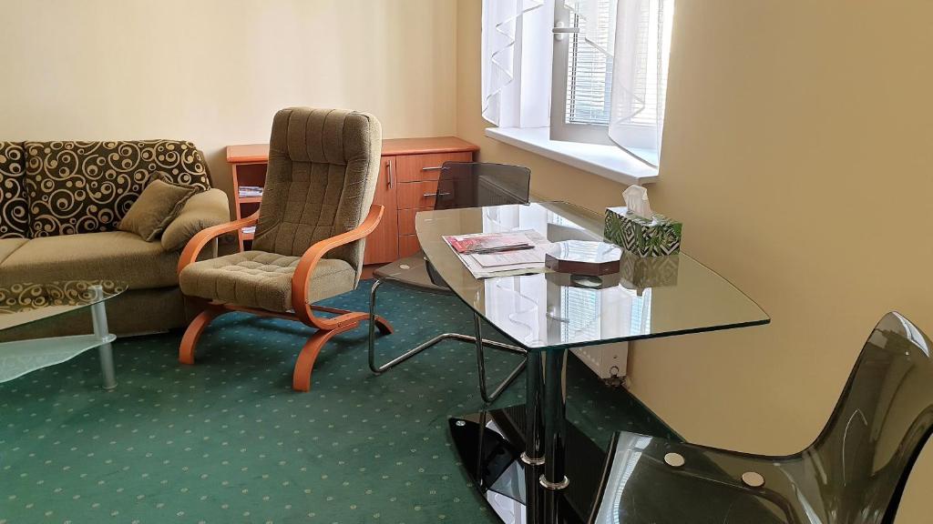 - un salon avec un canapé et une table en verre dans l'établissement SPA Apartment Raisova, à Karlovy Vary